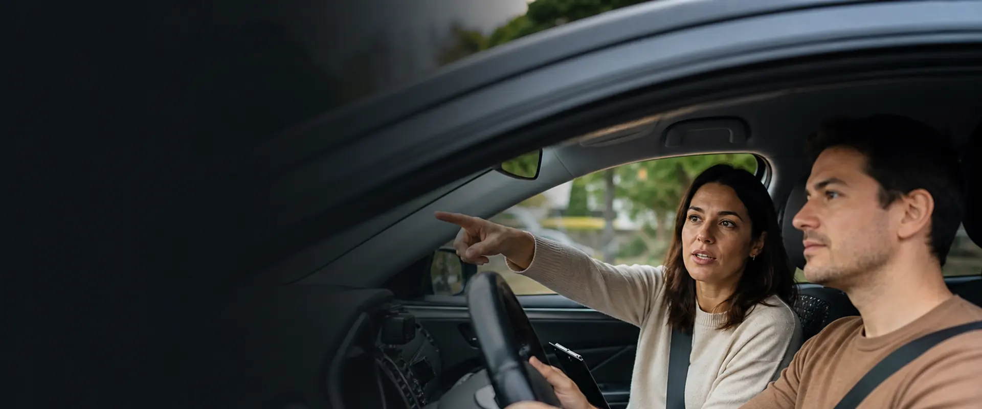 Profesora de autoescuela dando indicaciones a una alumna dentro del coche